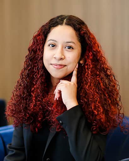 Headshot of Carmen Candia smiling with red curly hair