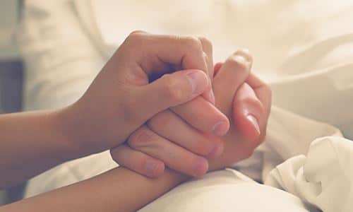 two hands being held on bedding